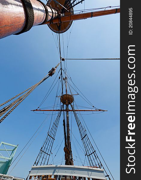 View of mast and rigging on the tall sail ship against the blue sky. View of mast and rigging on the tall sail ship against the blue sky.
