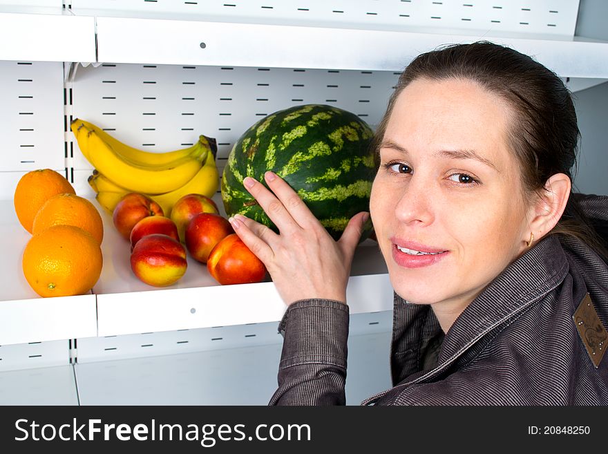 Image of a woman buying fruits in a market.