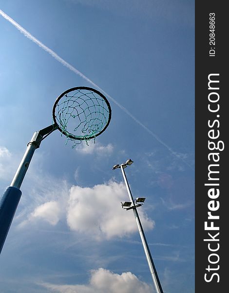 A netball net against an interesting blue sky with white cloud and vapour trail. A netball net against an interesting blue sky with white cloud and vapour trail.