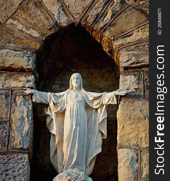 Image of an old statue of Christ in an exterior stone native church wall. Image of an old statue of Christ in an exterior stone native church wall.