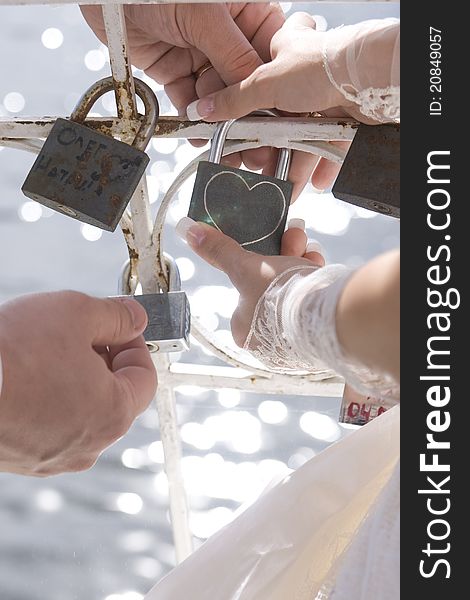 Wedding ceremony with padlock . hands newlyweds