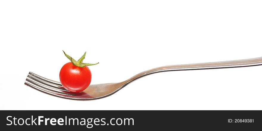 Tomato cherry on a fork on white