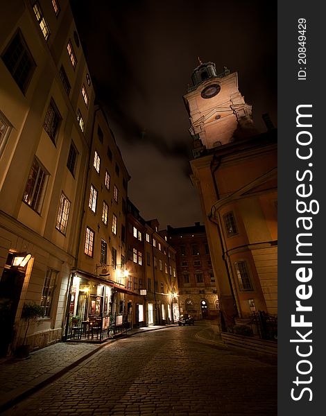 A back alley in Stockholm with a tall church in the background