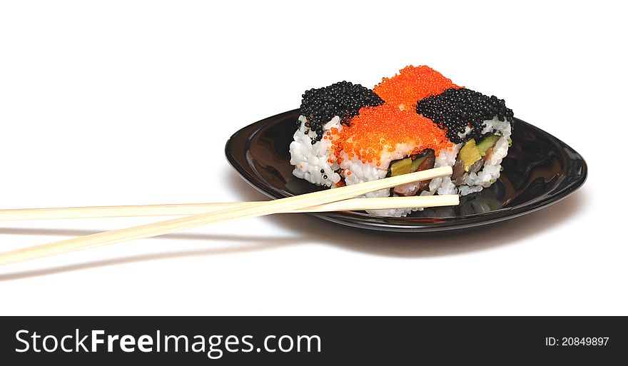 Closeup sushi with chopsticks on black plate