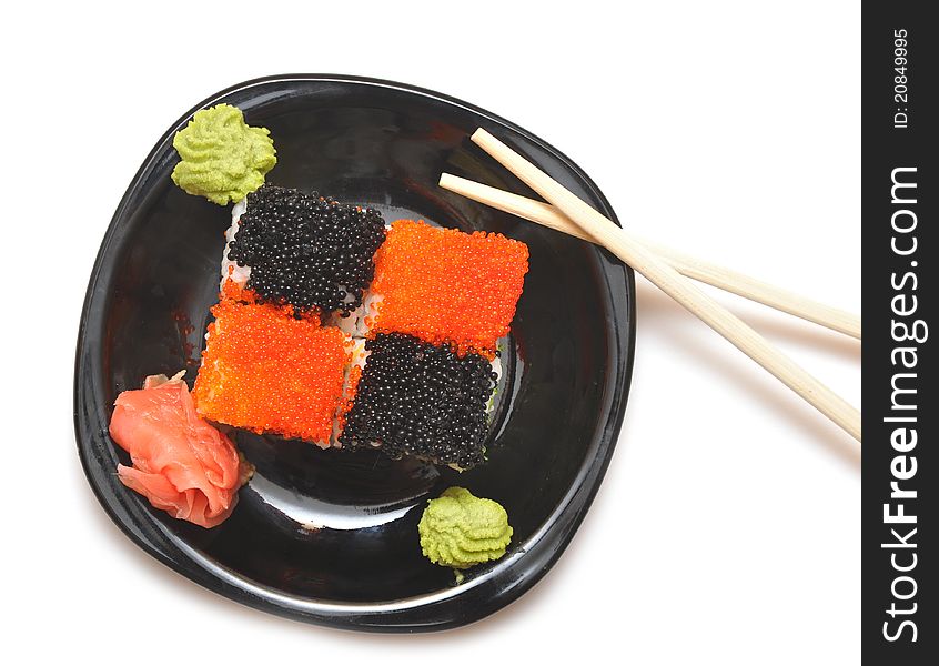 Closeup sushi with chopsticks on black plate