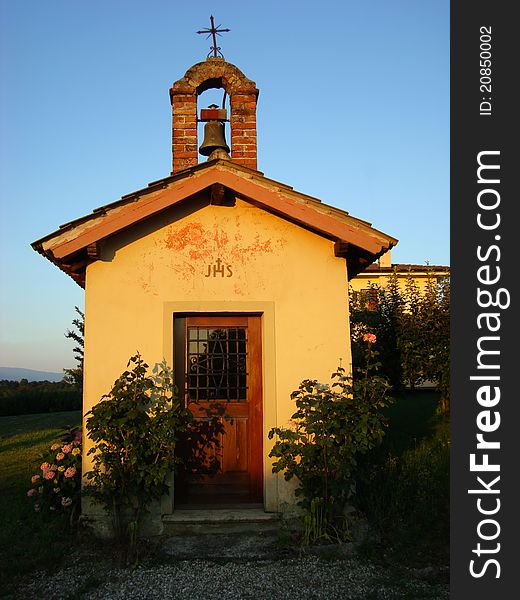 Small country church with a bell and cross, shooting at dusk in summer