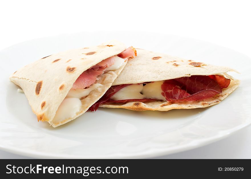 Two slices of flatbread with ham and mozzarella