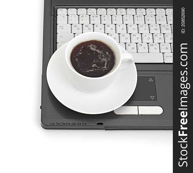A cup of coffee on a laptop on white background