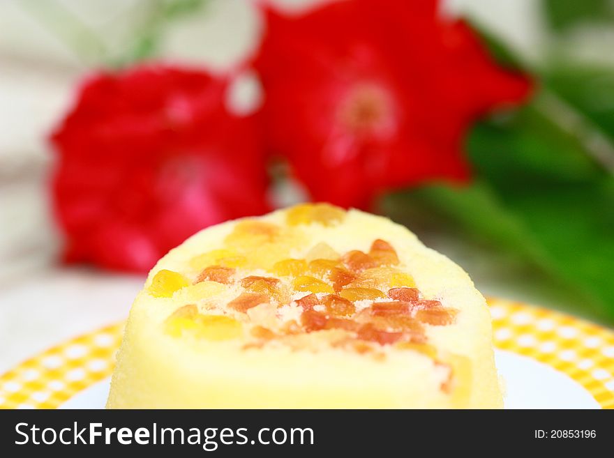 Plate with fruit cake decorating with red flower