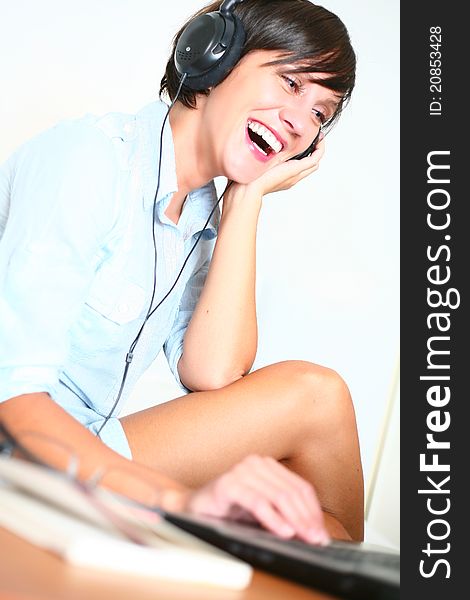 Beautiful girl listening music smiling while working on laptop