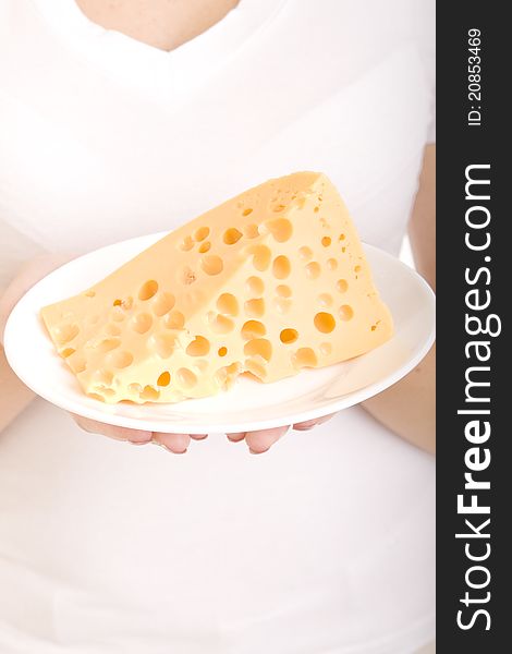Slice of cheese on a plate, in the hands of a girl. Slice of cheese on a plate, in the hands of a girl
