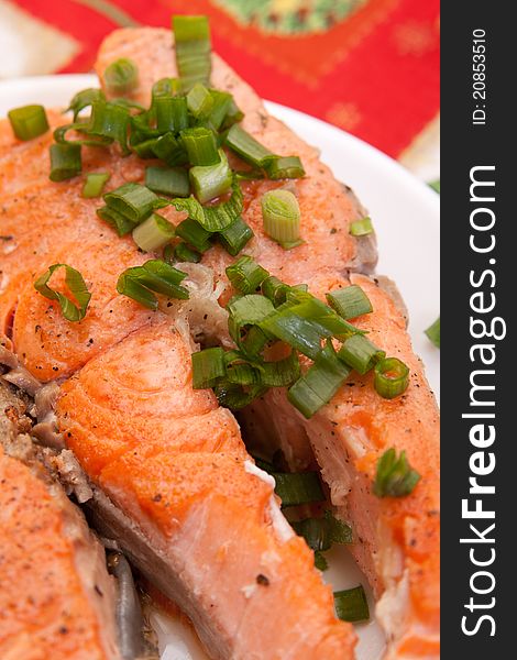 Plate with tasty salmon garnished with vegetables