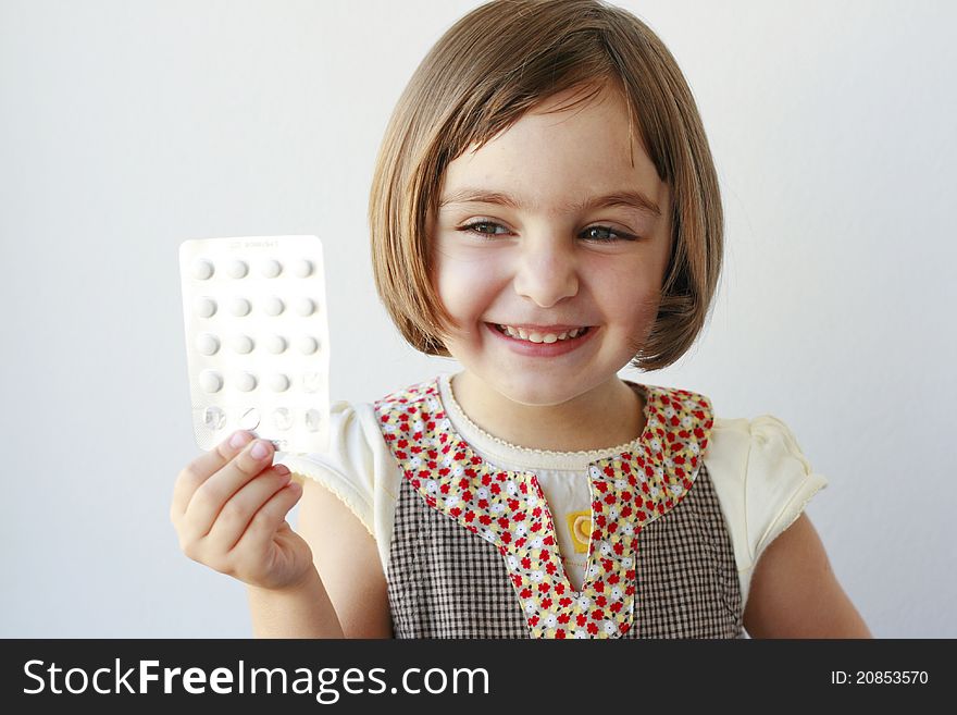 Little girl looking at the camera holding medicaments. Little girl looking at the camera holding medicaments