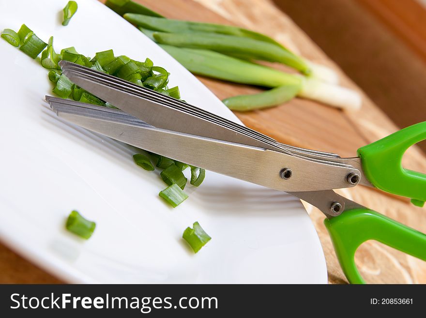 Scissors unusually green in the kitchen with lots of blades on a white plate, shown in action. Scissors unusually green in the kitchen with lots of blades on a white plate, shown in action