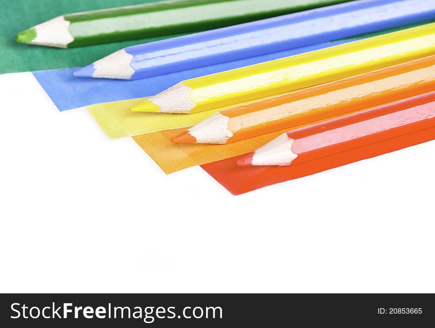 A colorful pencil crayons and scrapbooking papers ready for creative use. A colorful pencil crayons and scrapbooking papers ready for creative use.