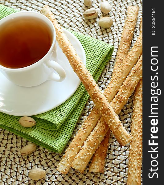 Cup of tea and crispy straw on table