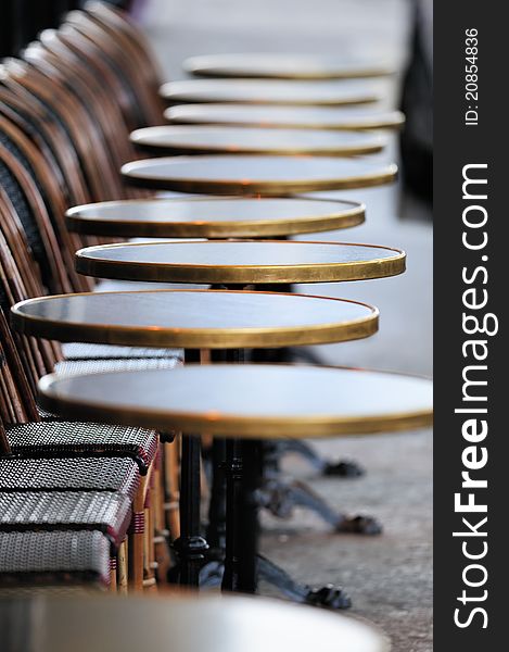 Several round tables in the typical cafe in Paris. Photo with tilt-shift effect