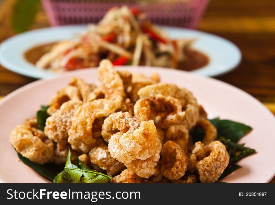 Crispy pork salted rind with thai herbal and papaya salad on the table