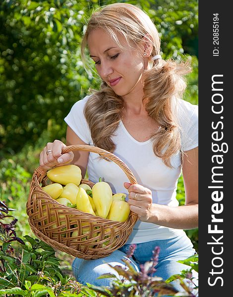 Young woman holding vegetables in the garden