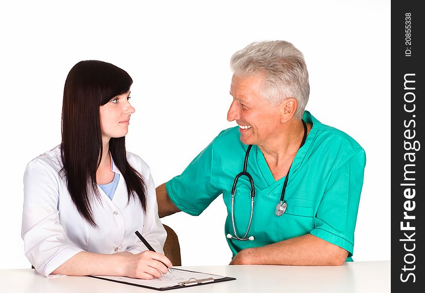 Cute doctor sits with nurse at table. Cute doctor sits with nurse at table