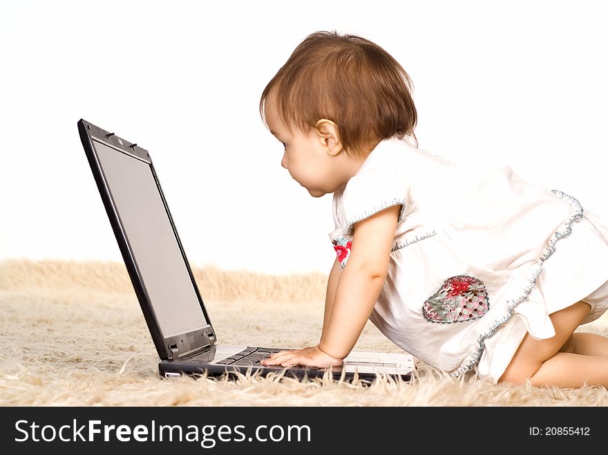 Cute little girl with laptop on a carpet. Cute little girl with laptop on a carpet