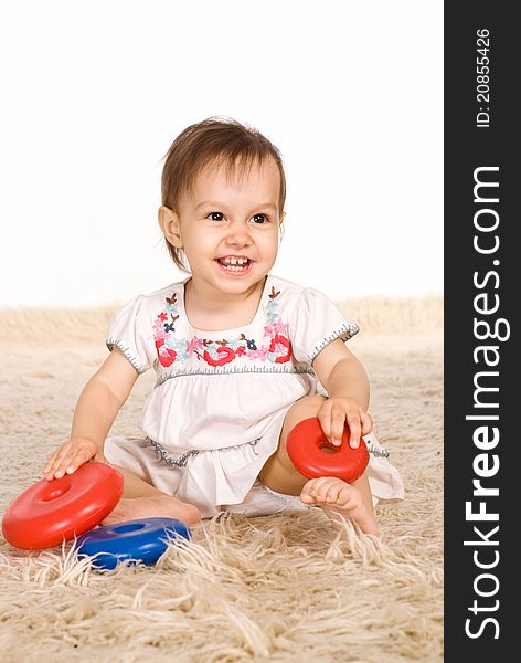 Little girl playing on a carpet on white. Little girl playing on a carpet on white