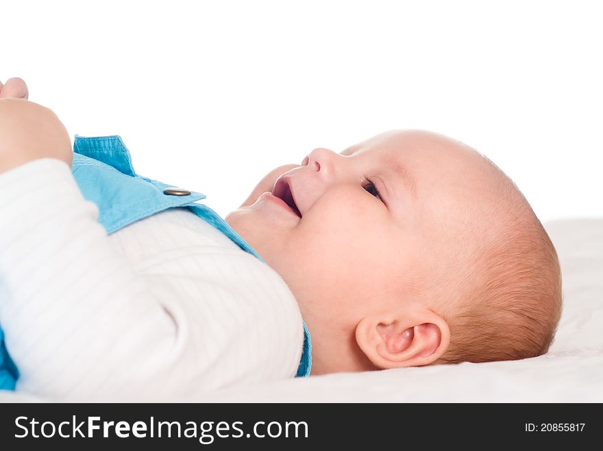 Portrait of a cute baby lying on bed on a white. Portrait of a cute baby lying on bed on a white