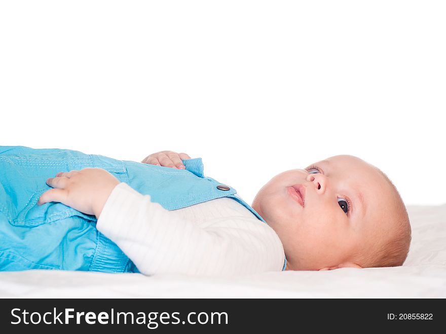 Portrait of a cute baby lying on bed on a white. Portrait of a cute baby lying on bed on a white