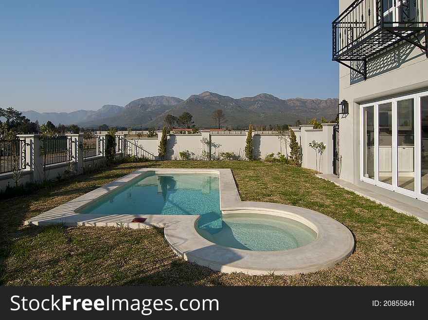 Exterior of a luxury housze with a swimming pool on a sunny day. Exterior of a luxury housze with a swimming pool on a sunny day