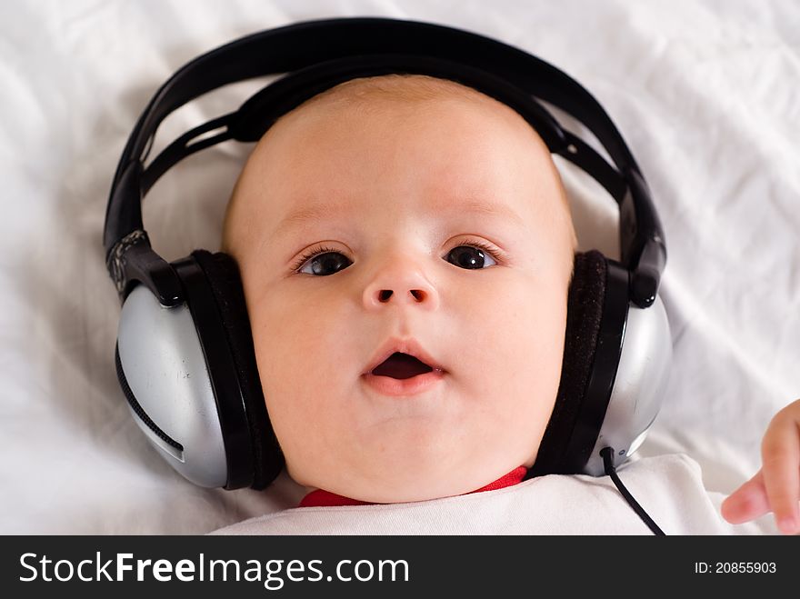 Cute little baby with headphones on white. Cute little baby with headphones on white
