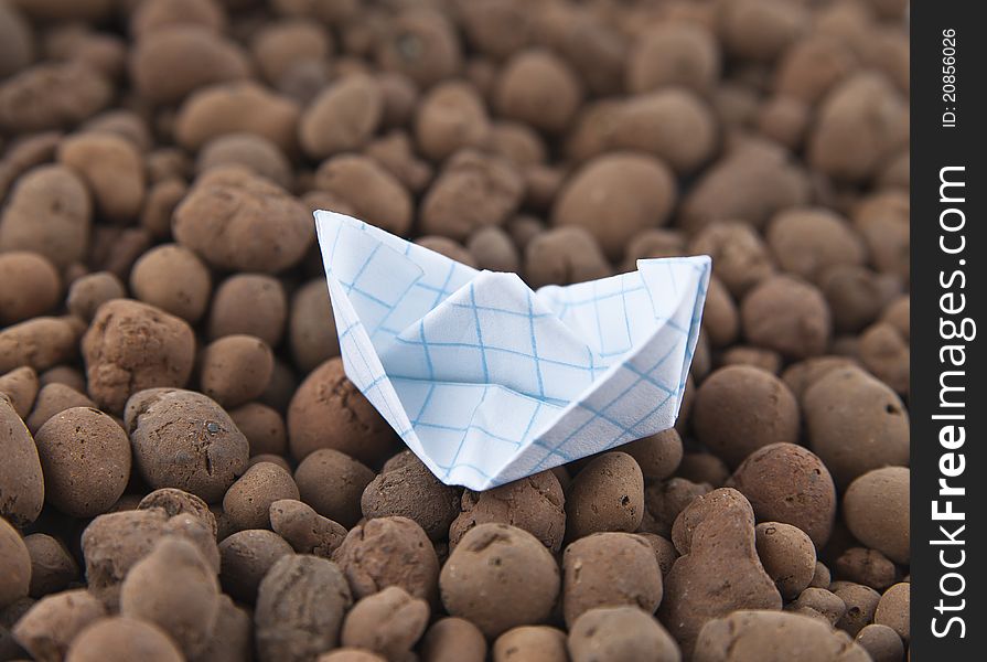 White paper boat in the small stones. White paper boat in the small stones