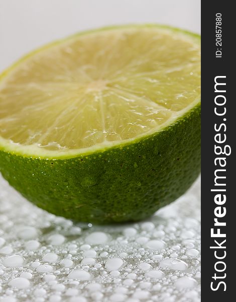 Lime with water drops on white