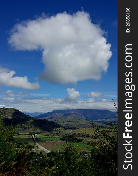 A big cloud hanging over a valley in Queenstown New Zealand