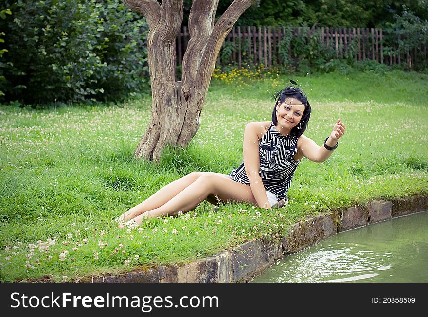 The girl on a grass at lake