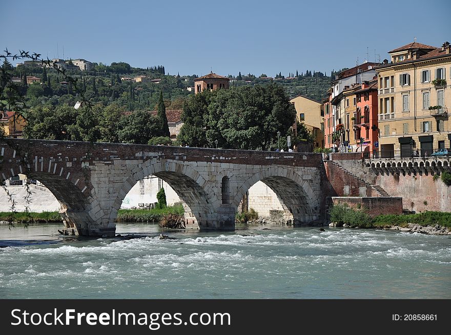 Bridge above the river, green heel and buildings in summer. Bridge above the river, green heel and buildings in summer.