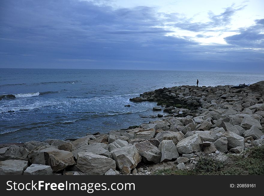 Cost with rock pier, cloudy sky, very blue. Cost with rock pier, cloudy sky, very blue.