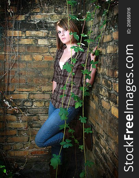 Young woman standing in corner with some vines. Young woman standing in corner with some vines