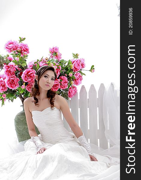 Portrait of young beautiful girl with flower on white background