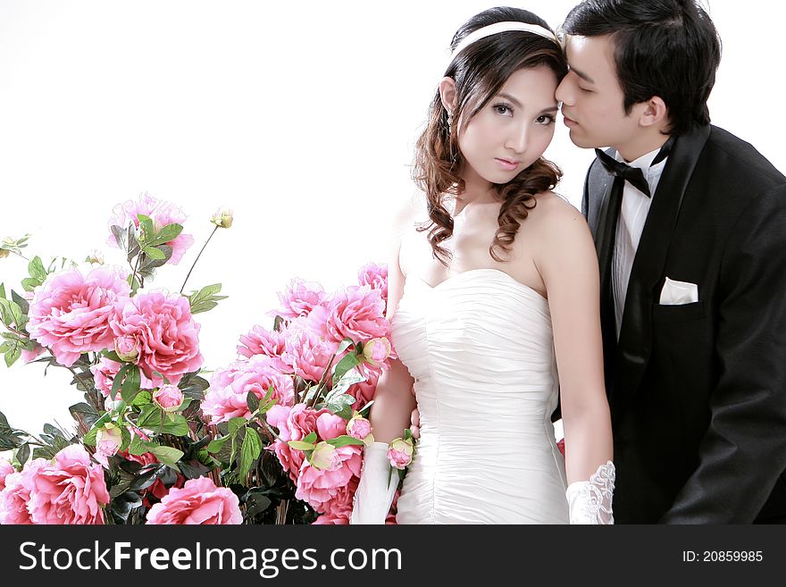 Portrait of young bride and groom kissing each other with sweet