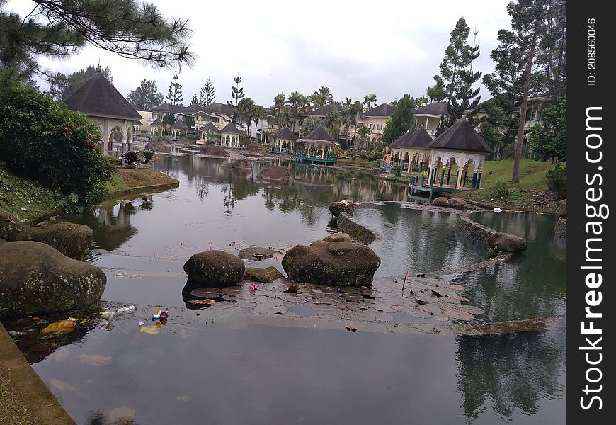 Little Lake And Stones Around, Cianjur, Indonesia - 2021. Tropical lake with buildings behind, beautiful and awesome for recreation place