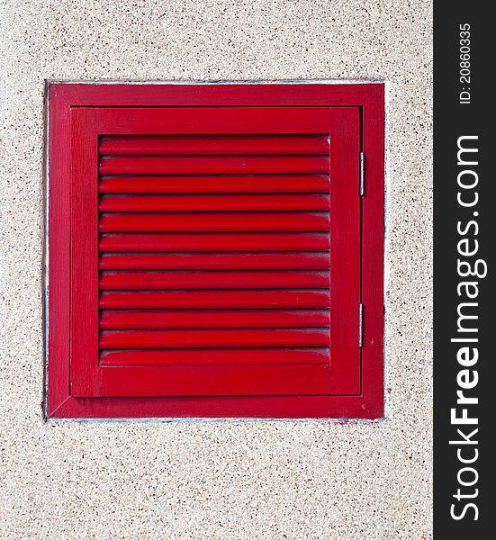 A picture of a red window on a concrete wall.