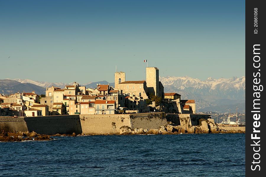 View of the old part of Antibes, France, from the beach La Salis, with the Alps in background. View of the old part of Antibes, France, from the beach La Salis, with the Alps in background.