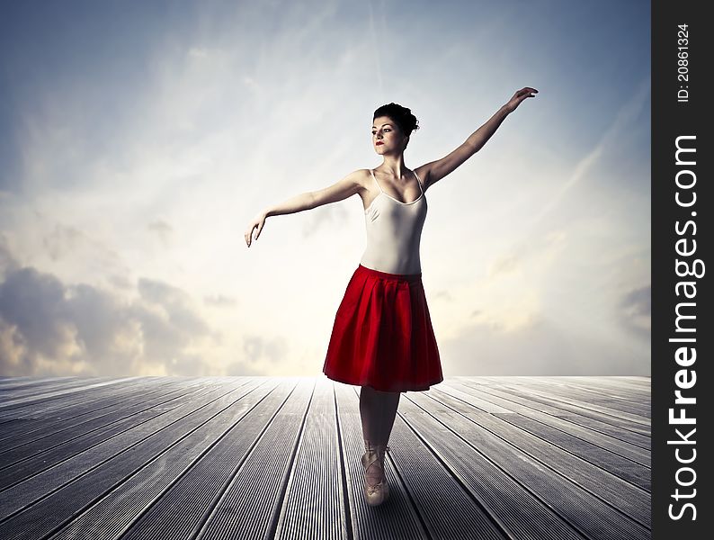 Beautiful ballerina standing on a wooden floor