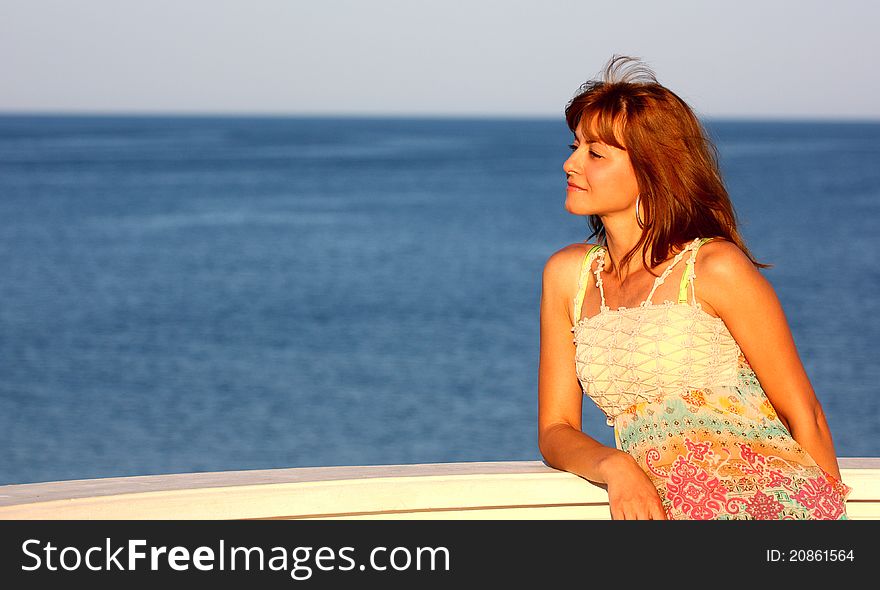 Beautiful woman relaxing wile watching a sea ( ocean ) outdoor. Beautiful woman relaxing wile watching a sea ( ocean ) outdoor