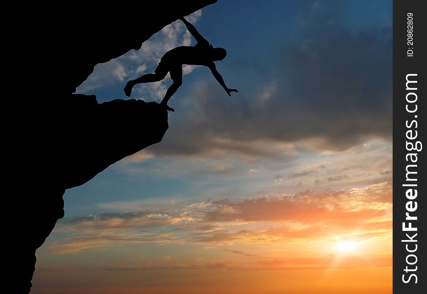 Man on top of the mountain reaches for the sun