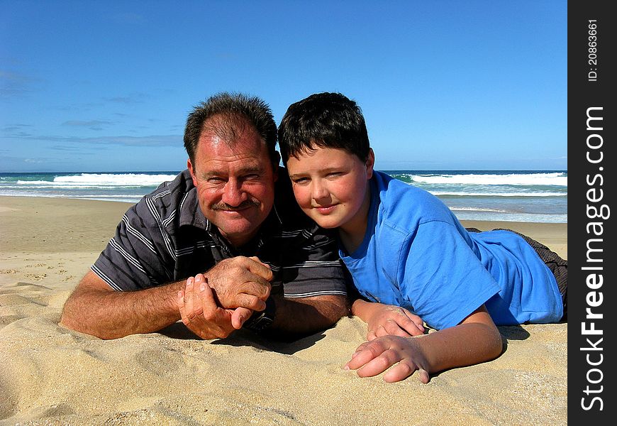 Friendly father and his son on the beach having a good time together. Friendly father and his son on the beach having a good time together.