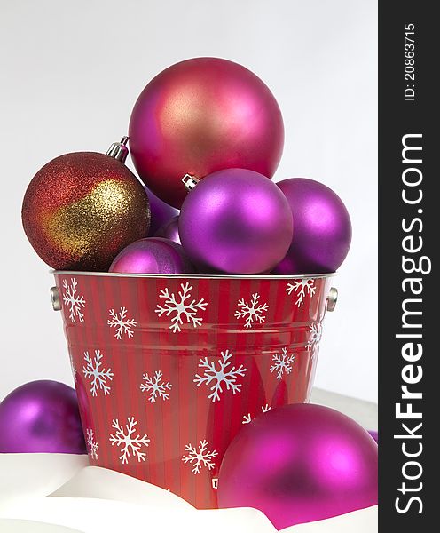 Bucket of red gold and purple christmas ornaments. Bucket of red gold and purple christmas ornaments