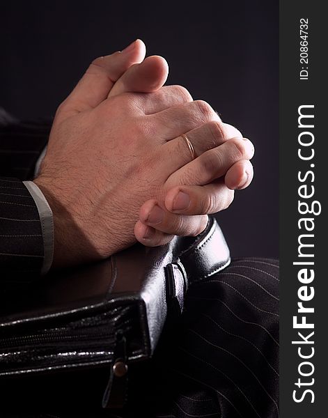 The hands of a businessman carrying a briefcase