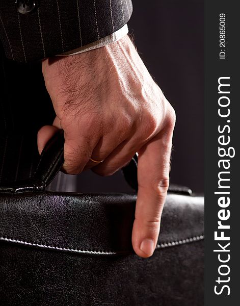 The hands of a businessman carrying a briefcase