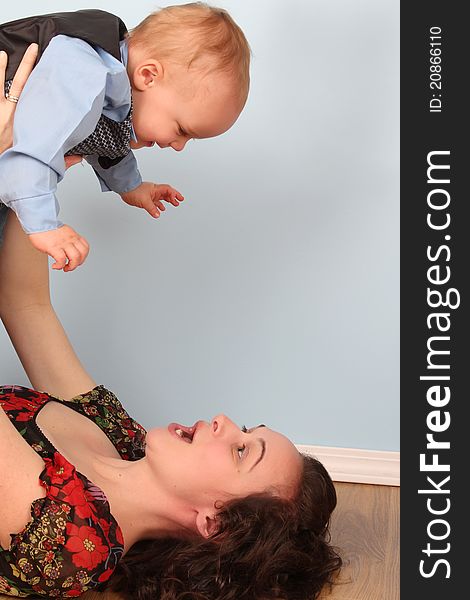 Mother and son playing indoors on a wooden floor